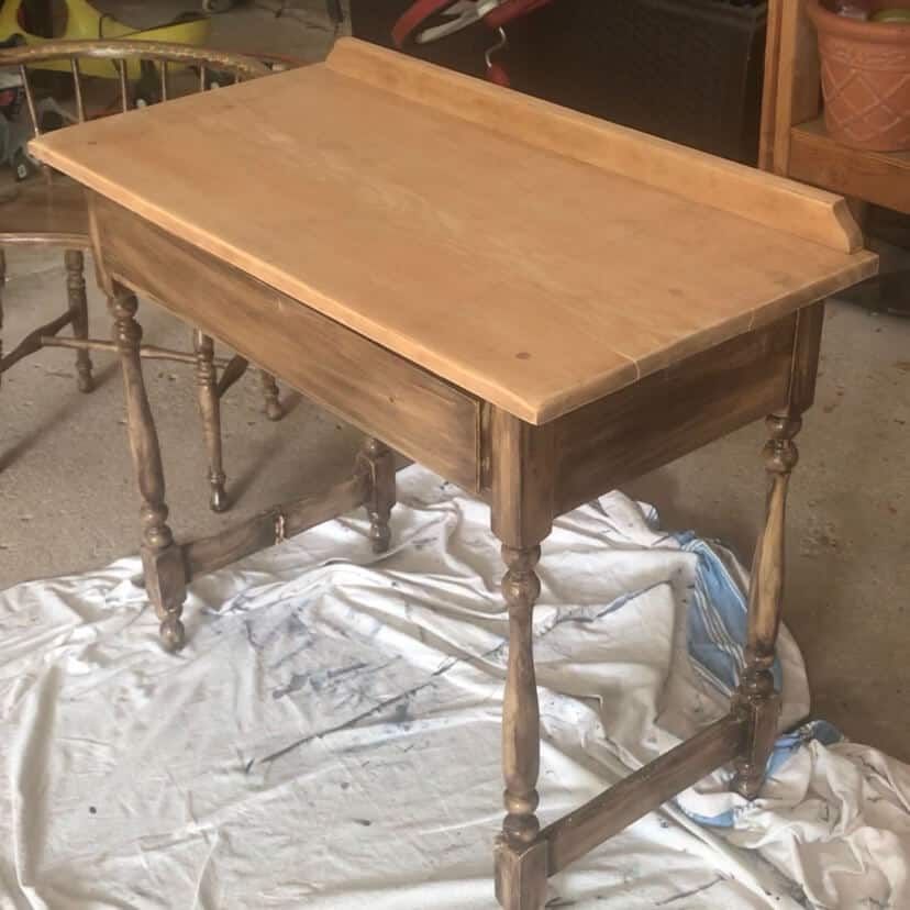 The top of a table that has been stripped, sanded and cleaned, and has a pinkish undertonw to the wood.