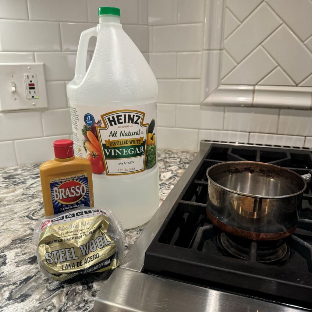 Supplies for cleaning furniture hardware. Pictured: vinegar, steel wool, Brasso cleaner.