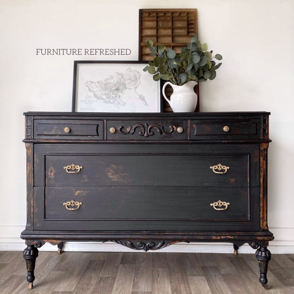 Antique dresser with a black chippy finish after being painted with milk paint.