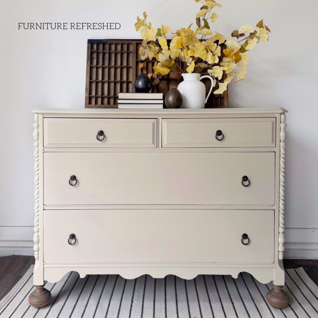 This is the after photo of the dresser used in this makeover. It has been painted in a ligth toasted almond color, has updated oil-rubbed bronze ring pulls and raw wood bun feet. 