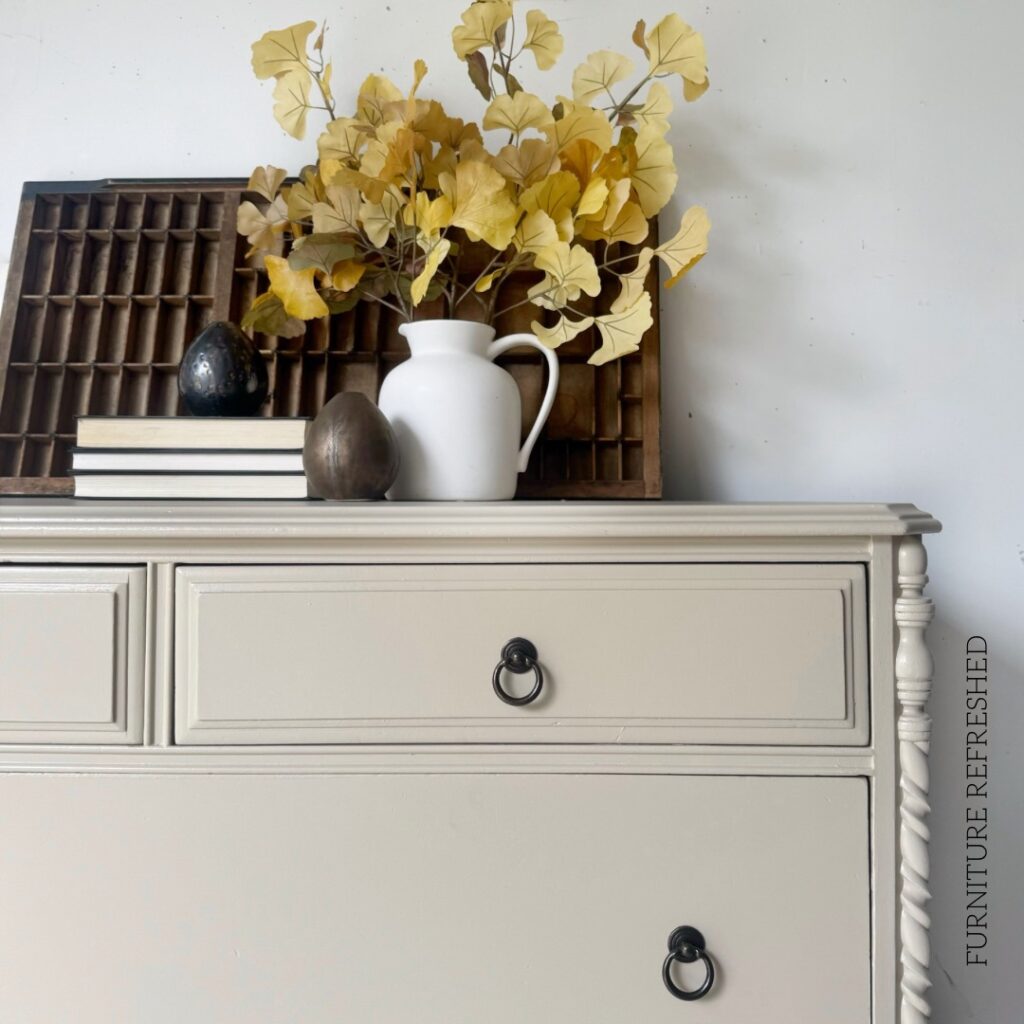 Close up photo of top corner of dresser. Shows new ring pulls and wood trim detailing on the side.