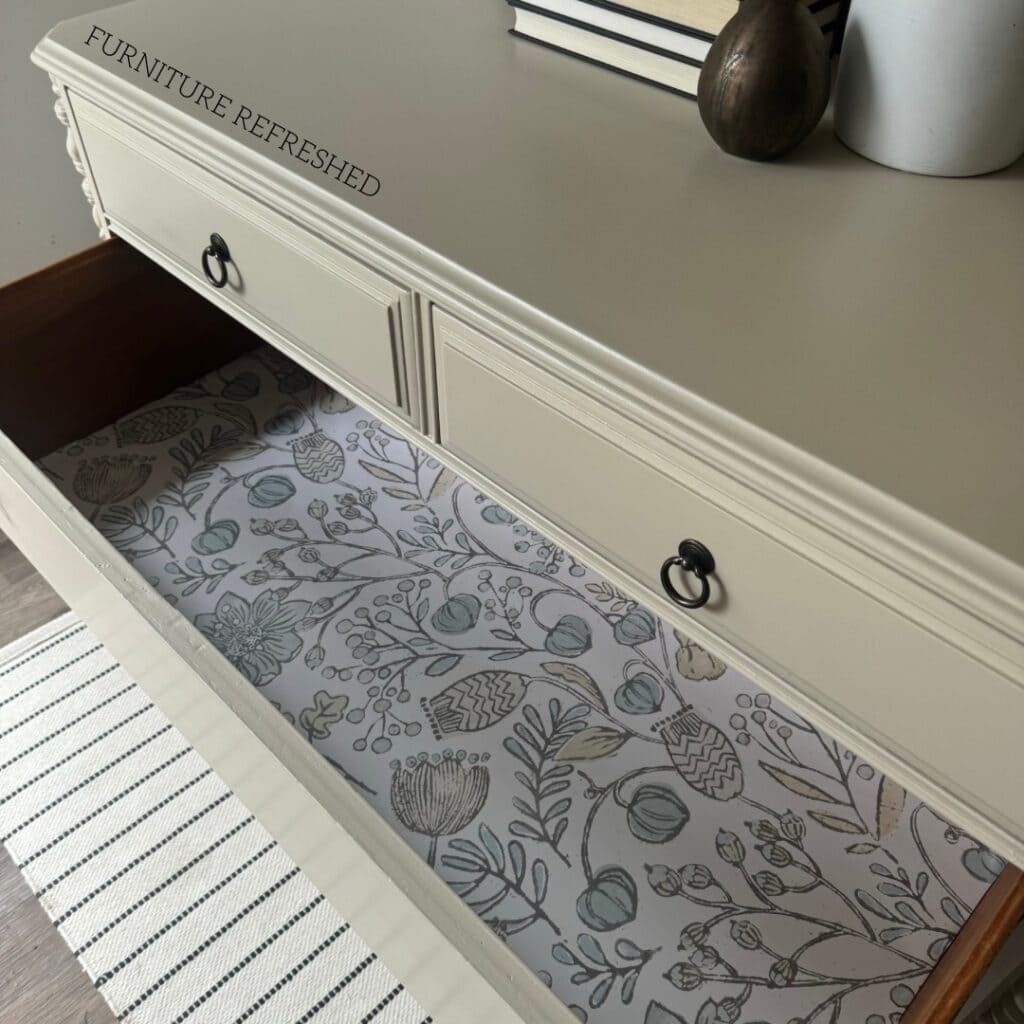 Photo of an open drawer showing the floral wallpaper used as a drawer liner.