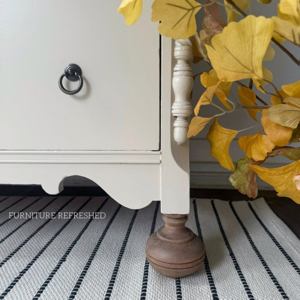 Closeup of the bottom corner of the dresser, showing the details of the bun feet.