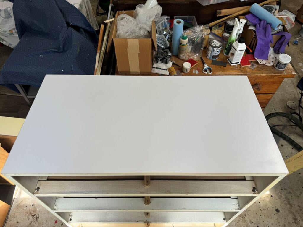 Top of the dresser, which is made of white laminate.