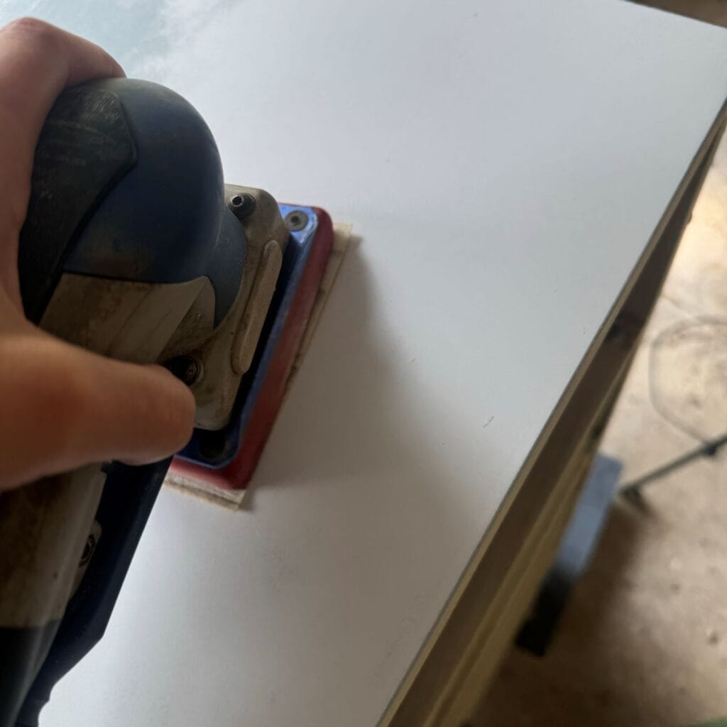 Close up of sander on the laminate top of this dresser.