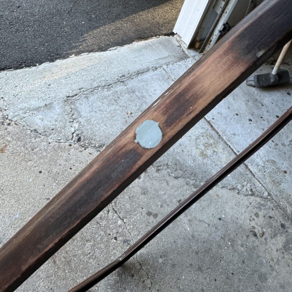 A bracket hole in the side of a mirror filled with Bondo and sanded smooth.