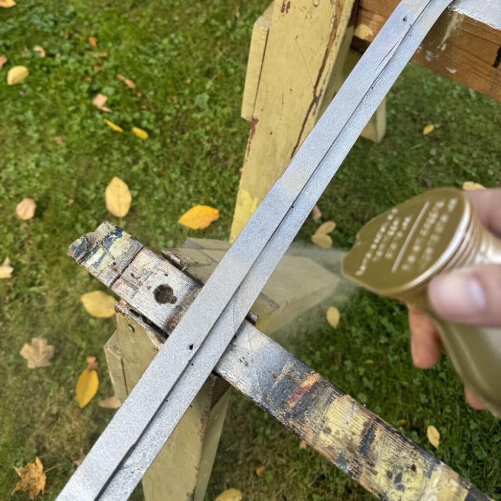 A photo of my spray painting the back of a mirror frame light metallic brass.