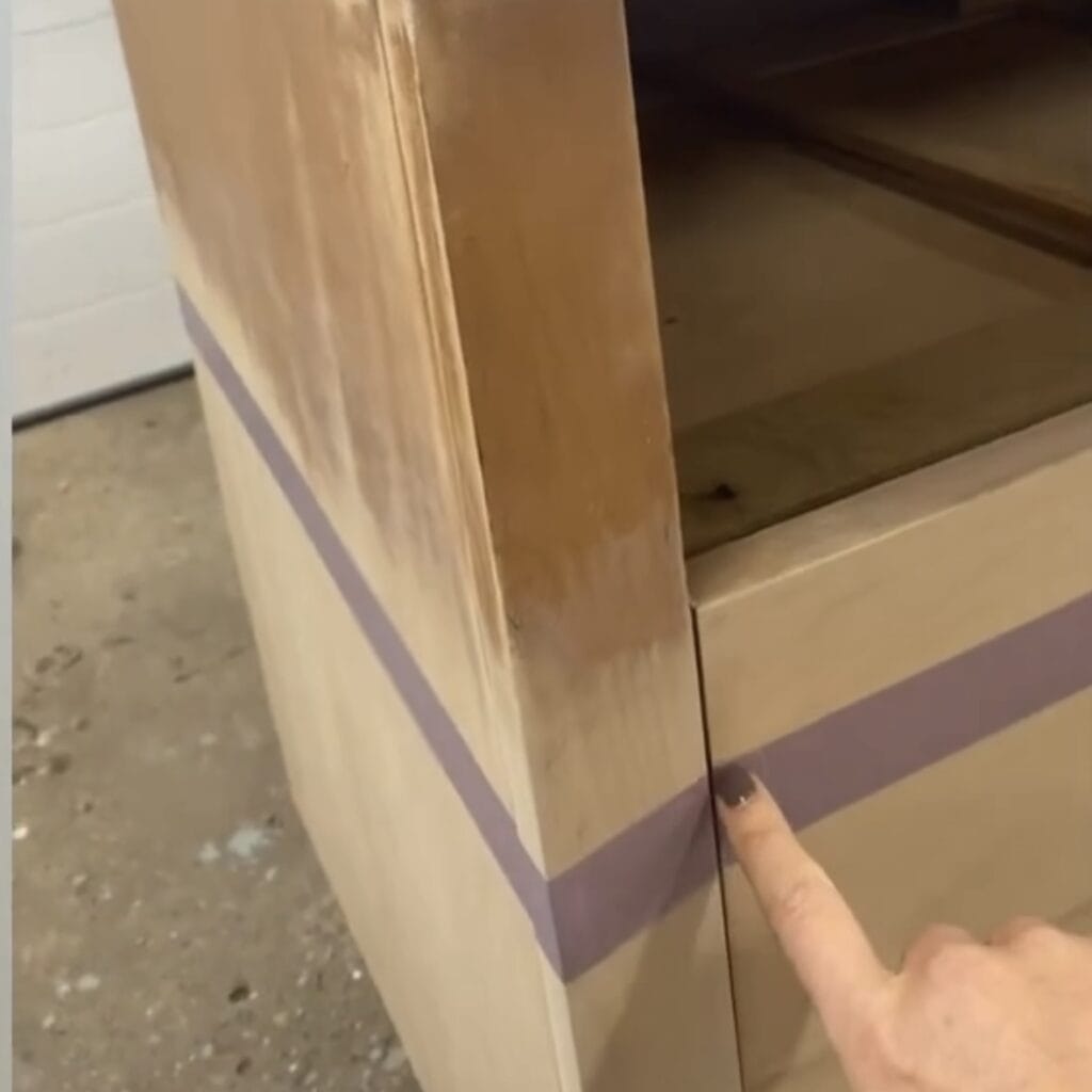 Tape applied to dipped dresser. A finger is pointing to the side of the tape where the line will be.