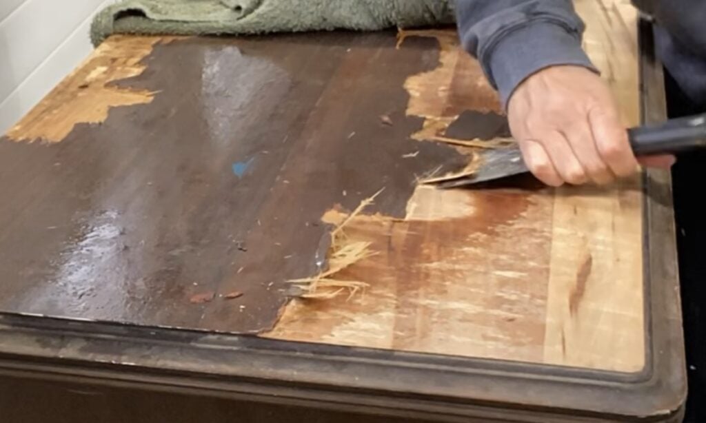 Photo of veneer removal using a putty knife.