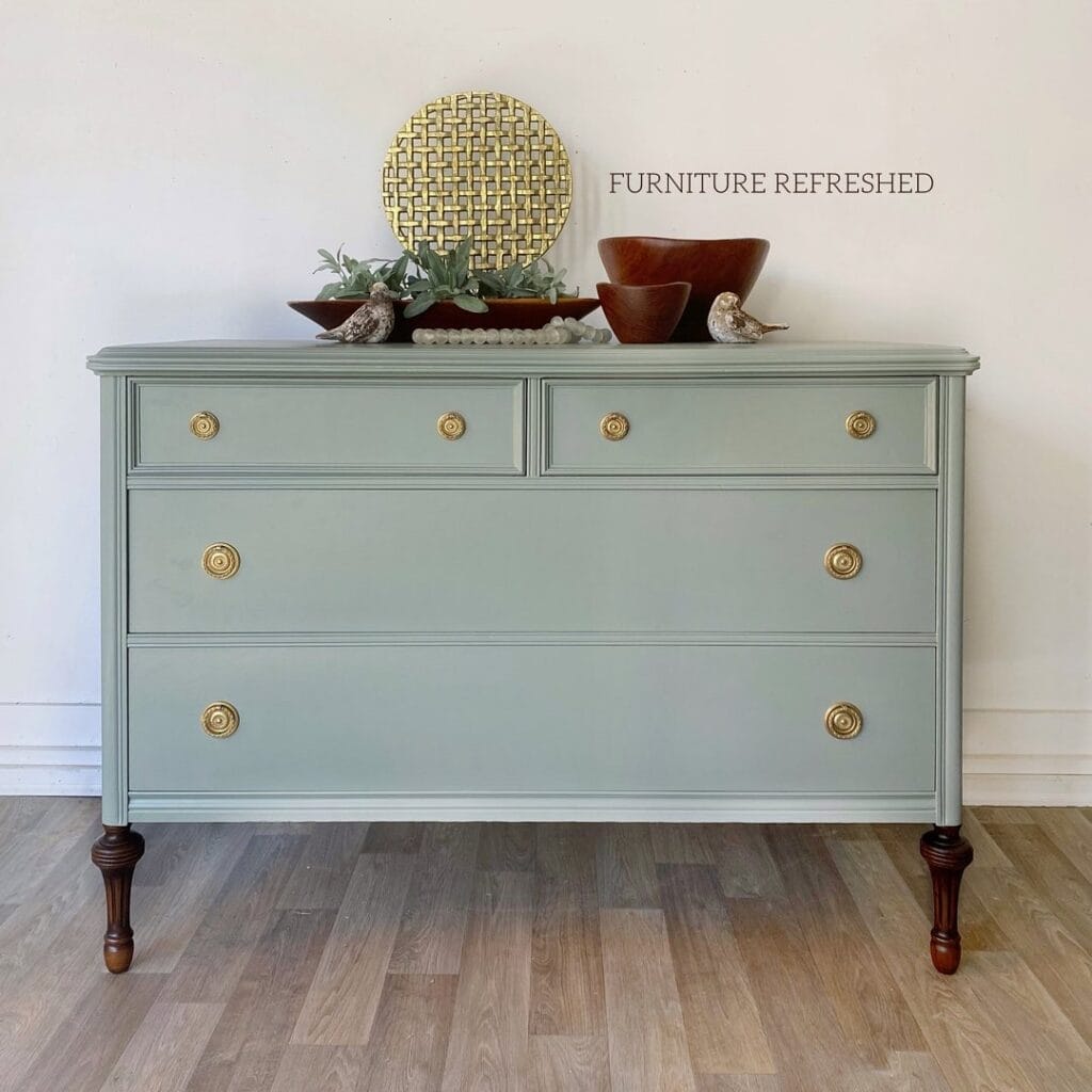 After photo of dresser that had veneer removed from top. The dresser has been painted a light blue/green color and had brass hardware.