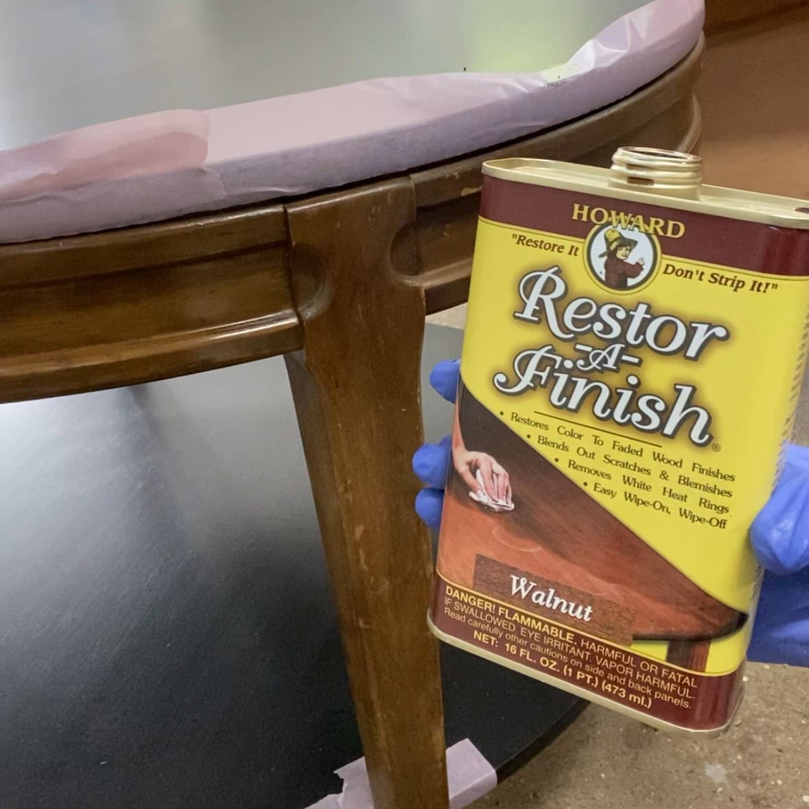 Photo showing a can of Howard's Restor-A-Finish next to a table leg with a worn finish.