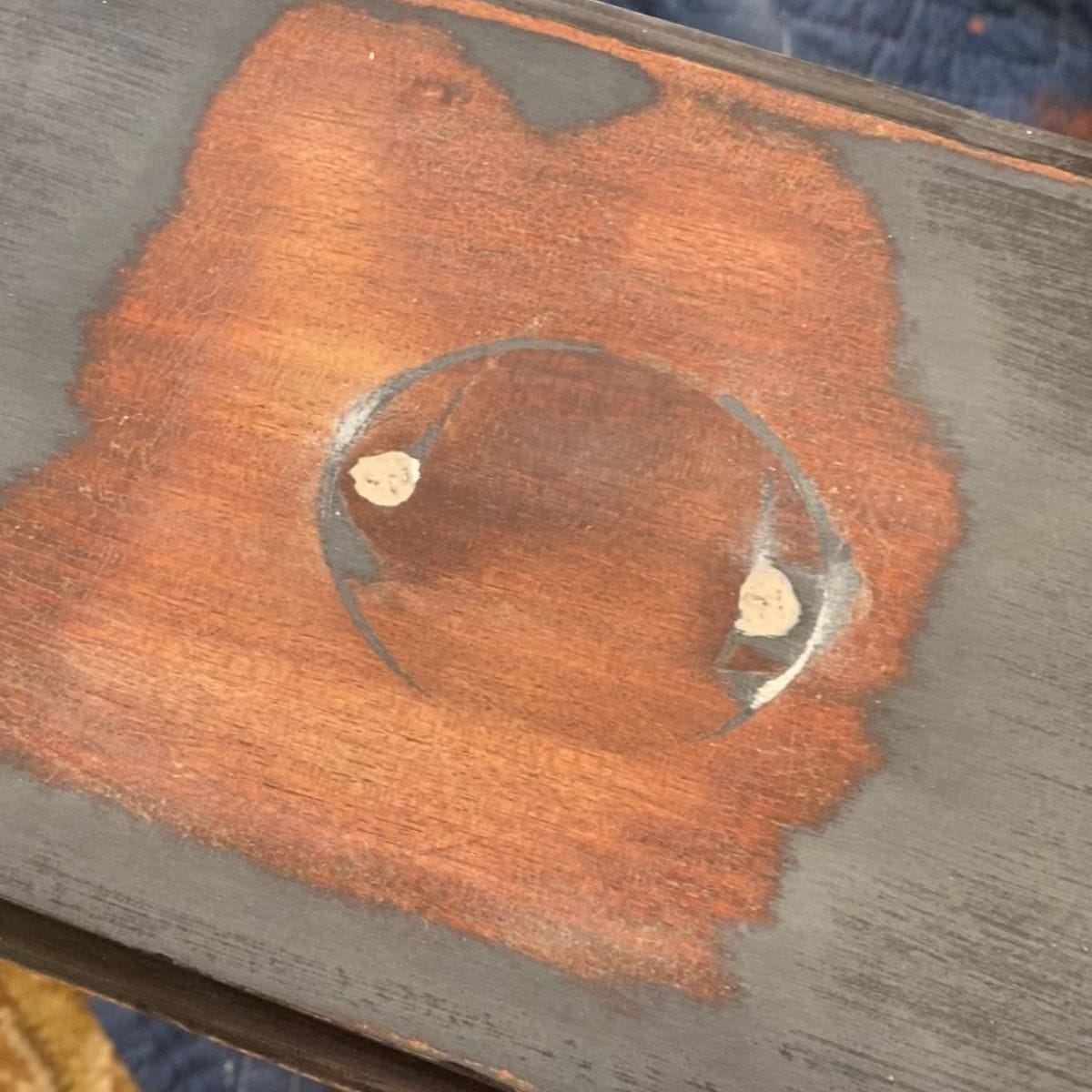 Close up of a drawer from the mahogany desk where the finish has been sanded completely off in places.