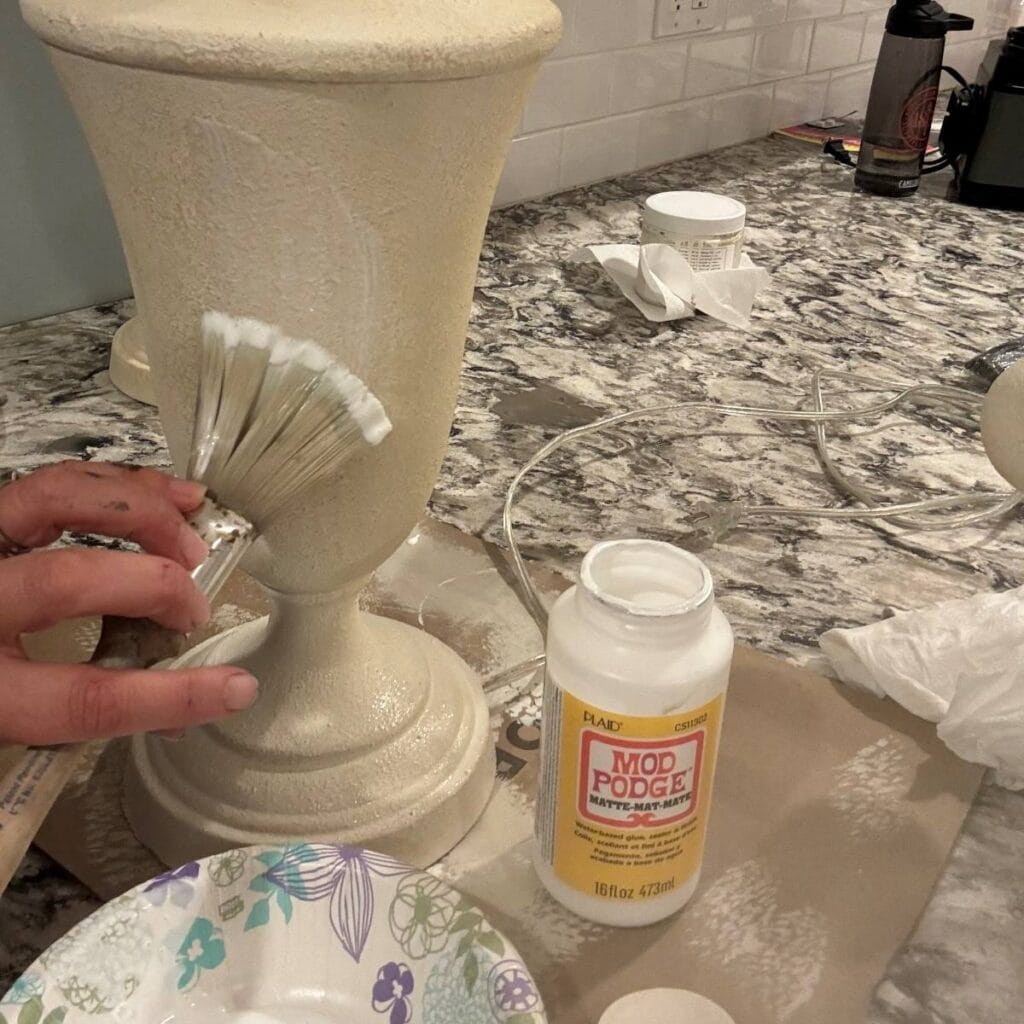 Sealing the faux stone finish with Mod Podge.