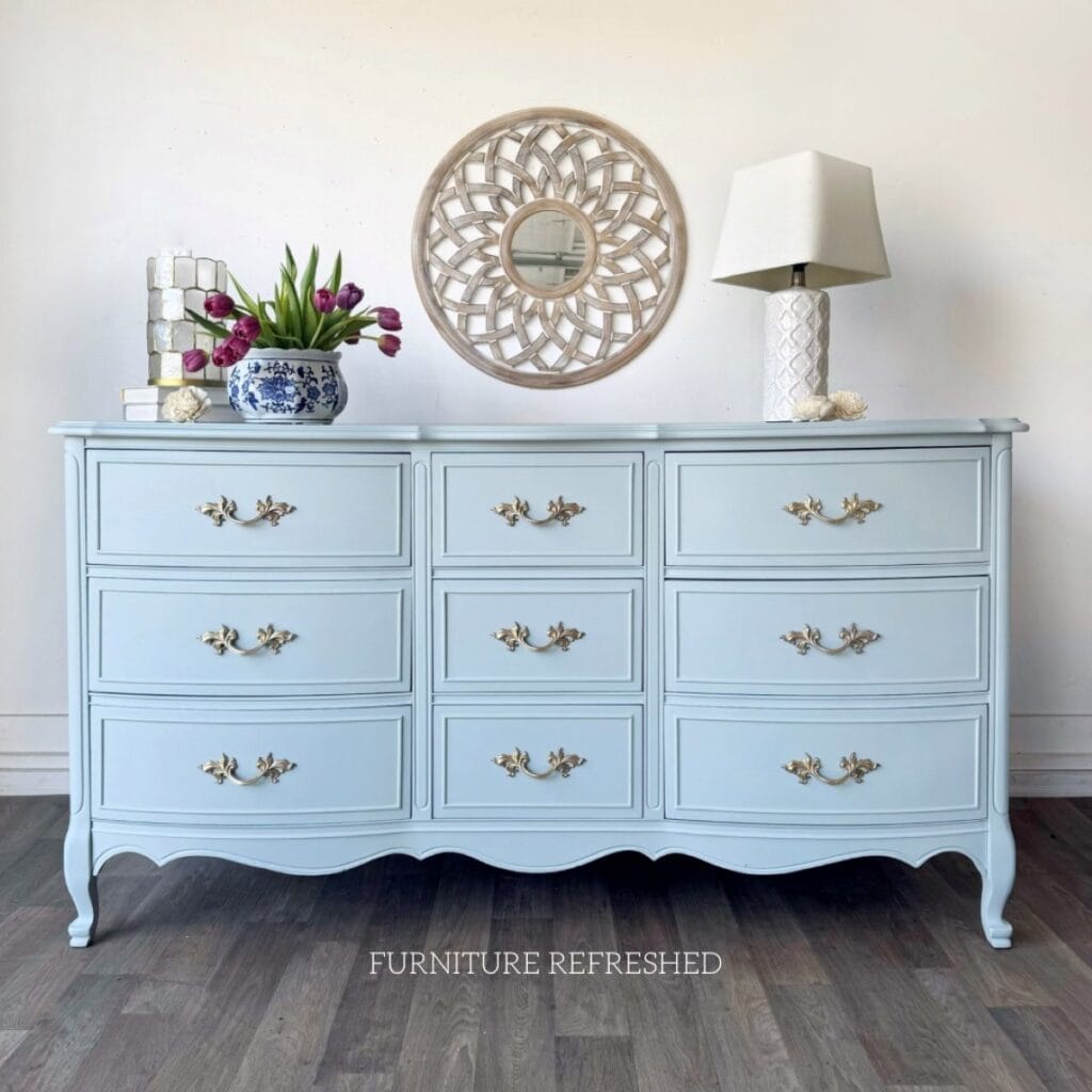 Photo of a light blue painted French Provencal lowboy dresser. 