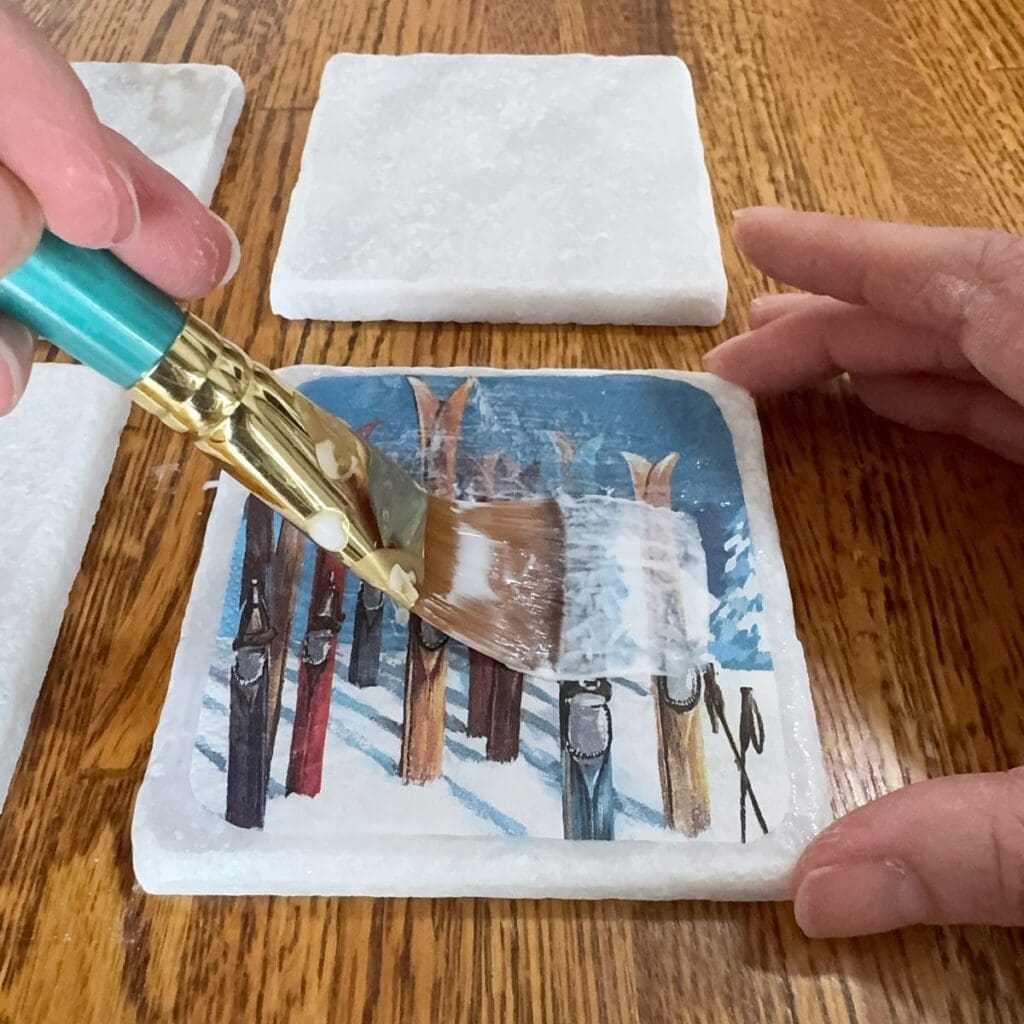 Applying mod podge over the napkin.