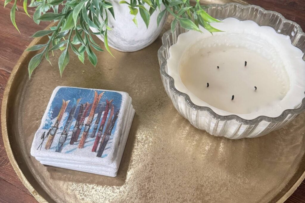 Display of completed coasters on a tray with a candle and greenery.