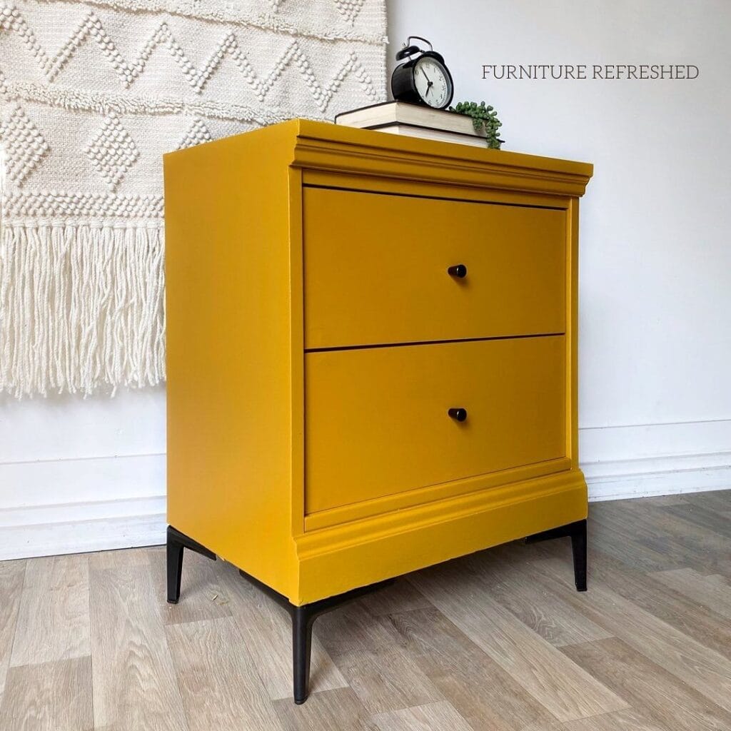 Yellow nightstand with black hardware and legs.