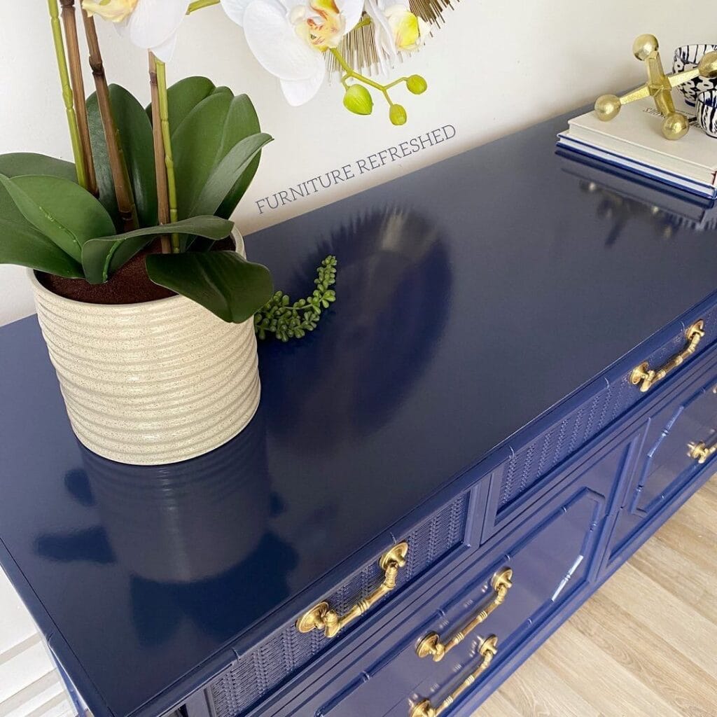 Close up of the top a a blue dresser with a glossy finish.