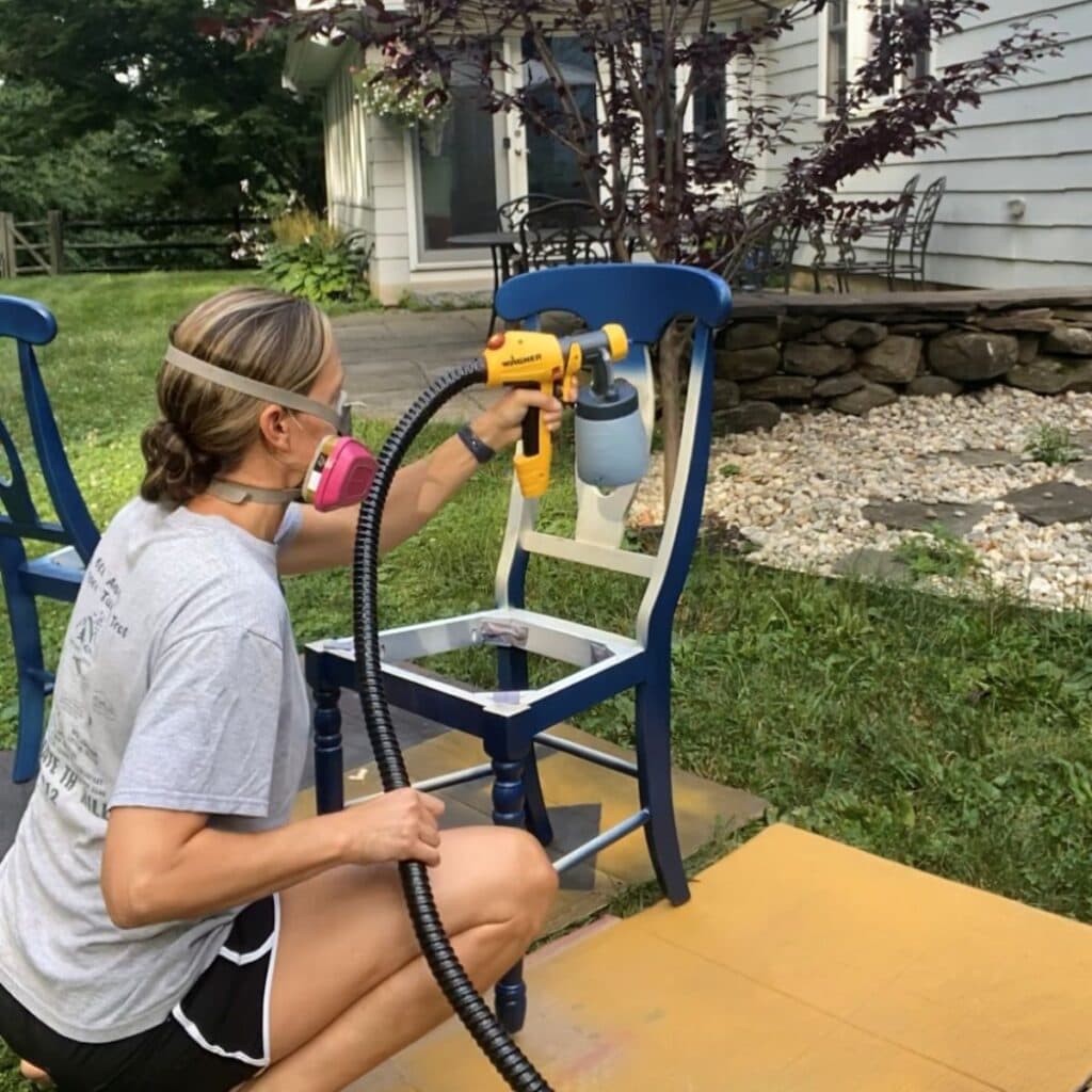 using a paint sprayer to paint a chair